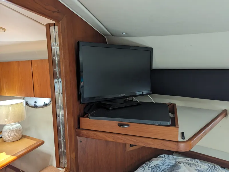 Slide: The Image of 2000 Tiara Yachts 3500 Express interior with TV and wooden cabinetry. - 16