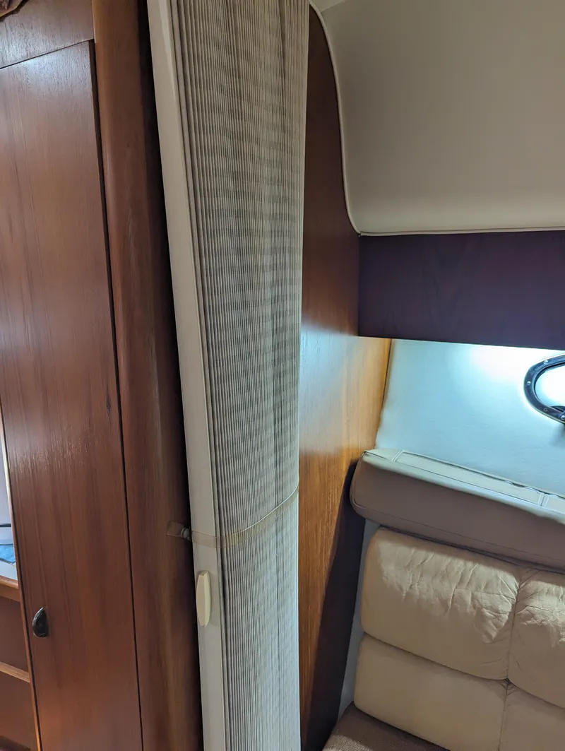Slide: The Image of Interior of a 2000 Tiara Yachts 3500 Express, featuring wood paneling and cushioned seating. - 18