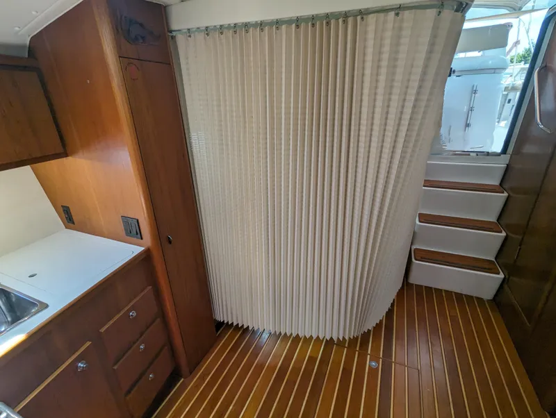 Slide: The Image of Interior of 2000 Tiara Yachts 3500 Express with wood flooring and kitchenette. - 19