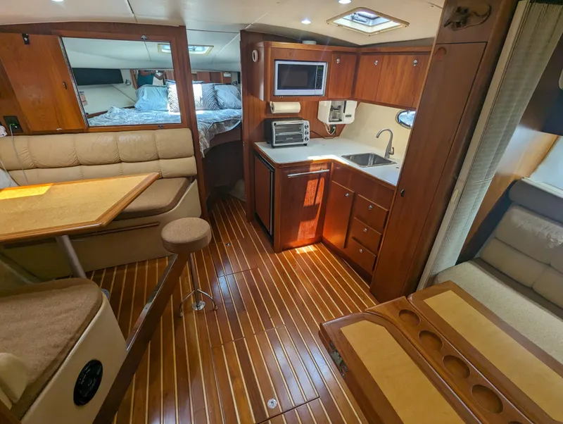 Slide: The Image of Interior of 2000 Tiara Yachts 3500 Express with kitchen, seating, and sleeping area. - 2