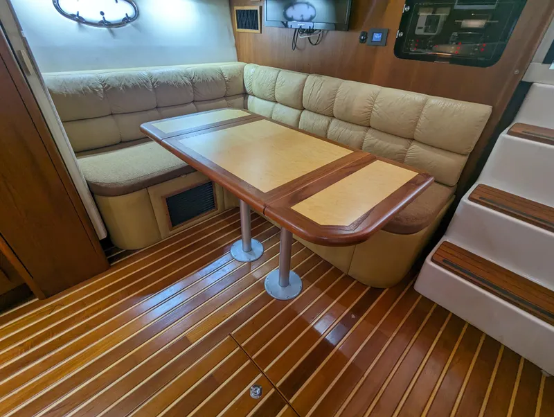 Slide: The Image of Interior of 2000 Tiara Yachts 3500 Express with wooden flooring and cushioned seating. - 3