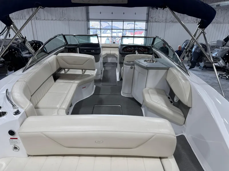 Slide: The Image of 2009 Cobalt 302 BR boat interior with white seating and modern dashboard. - 10