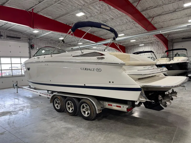 Slide: The Image of 2009 Cobalt 302 BR boat on a trailer in a spacious indoor showroom. - 4