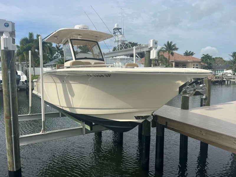 Slide: The Image of 2020 Scout 277LXF boat docked on a lift in a marina setting. - 0