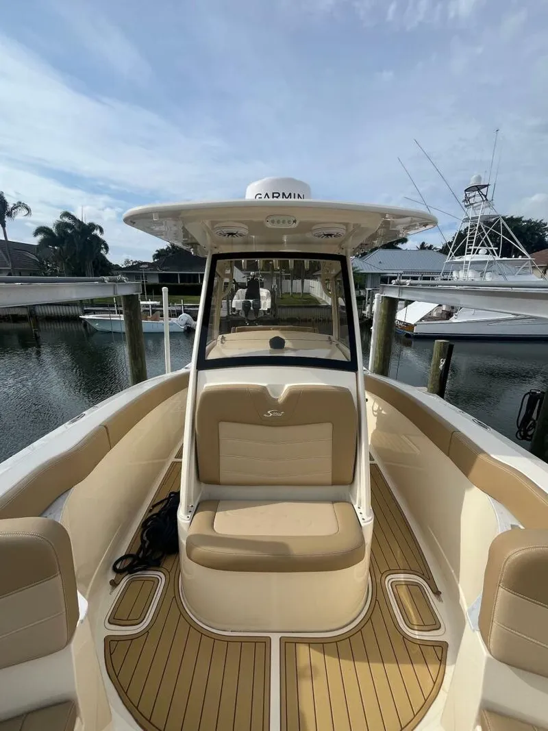 Slide: The Image of 2020 Scout 277LXF boat with tan seating, docked at a marina. - 11