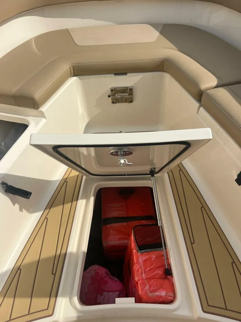 Slide: The Image of 2020 Scout 277LXF boat storage compartment with red life jackets inside. - 14