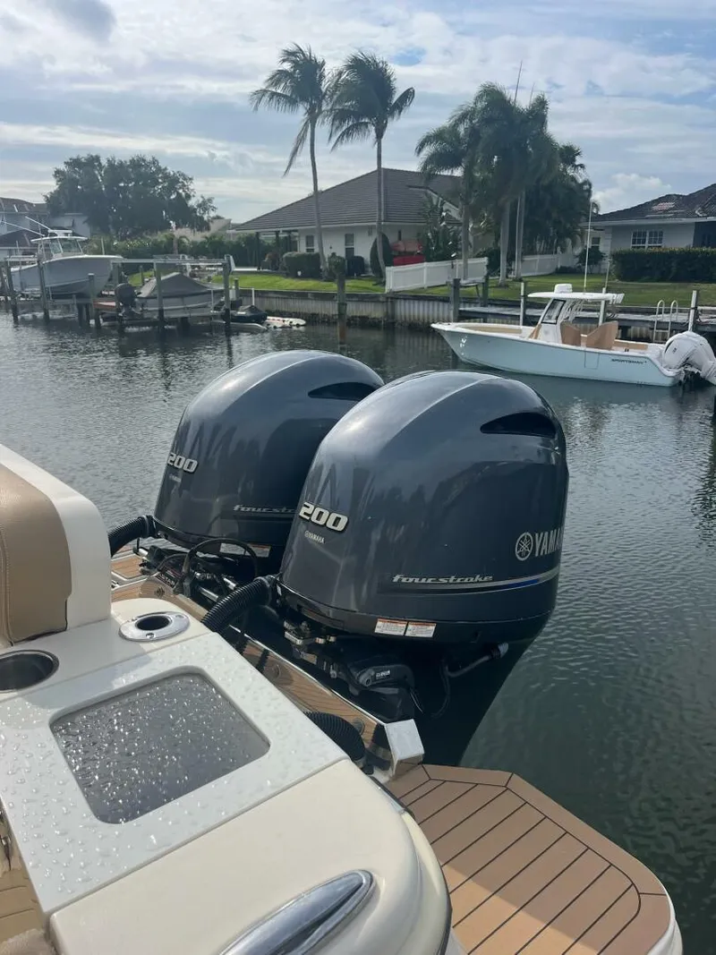 Slide: The Image of 2020 Scout 277LXF boat with twin Yamaha 200 engines docked by waterfront homes. - 19