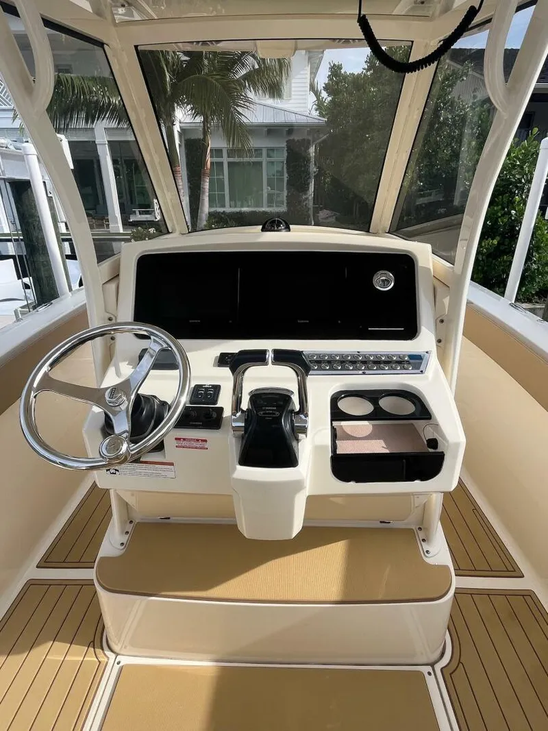 Slide: The Image of 2020 Scout 277LXF boat helm with steering wheel and control panel. - 2