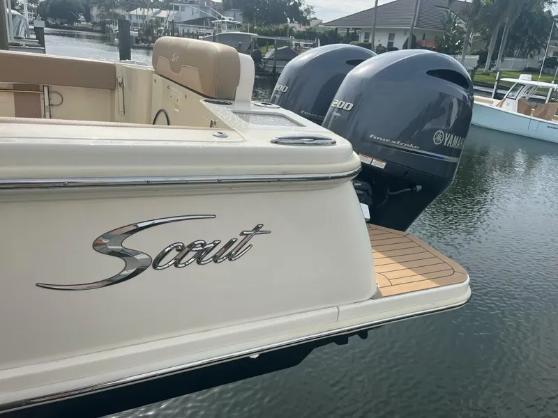 Slide: The Image of 2020 Scout 277LXF boat with twin Yamaha 200 engines docked by the water. - 20