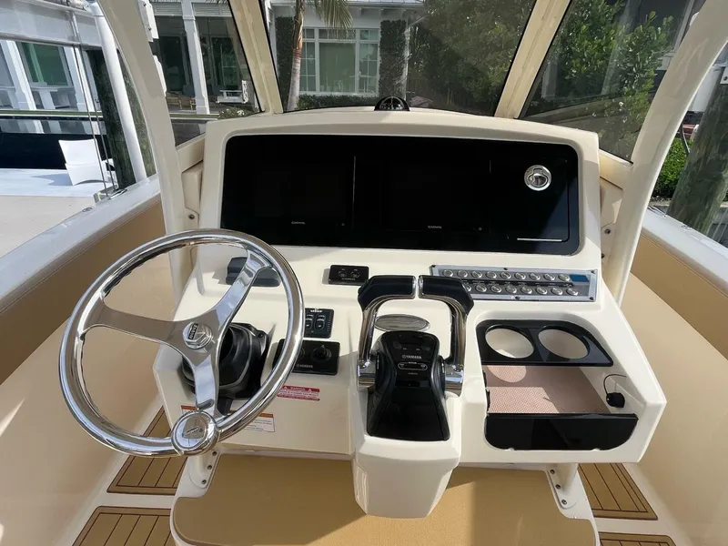 Slide: The Image of 2020 Scout 277LXF boat helm with steering wheel and control panel. - 3