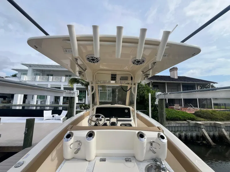 Slide: The Image of 2020 Scout 277LXF boat interior with rod holders and console, docked near waterfront homes. - 5