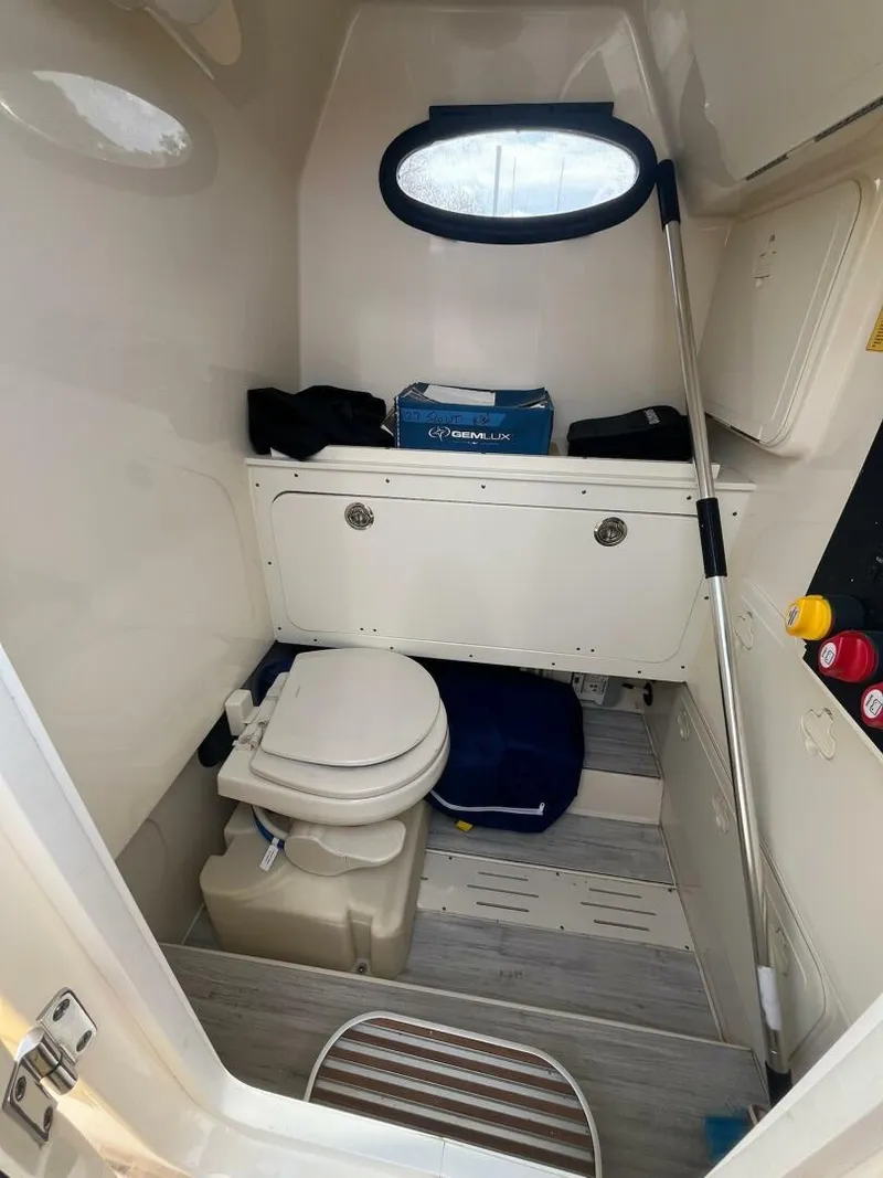 Slide: The Image of 2020 Scout 277LXF boat interior with compact marine toilet and storage. - 6