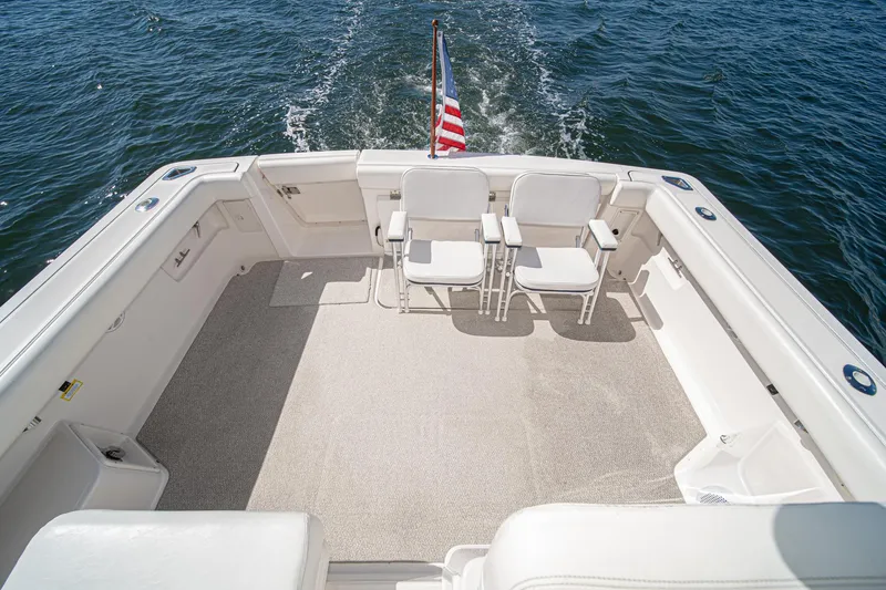 Slide: The Image of 2001 Tiara Yachts 3500 Open deck with chairs, American flag, and ocean view. - 15