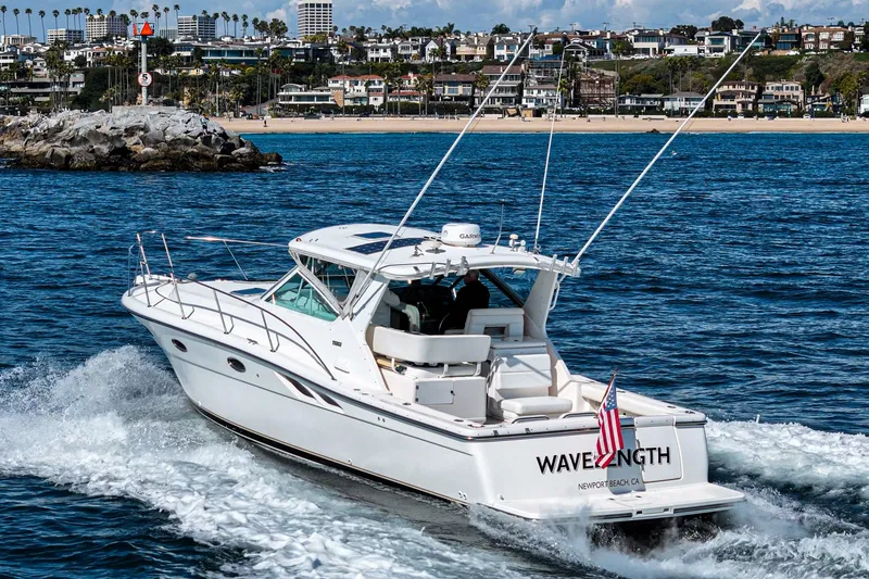 Slide: The Image of 2001 Tiara Yachts 3500 Open cruising near a coastal cityscape. - 2