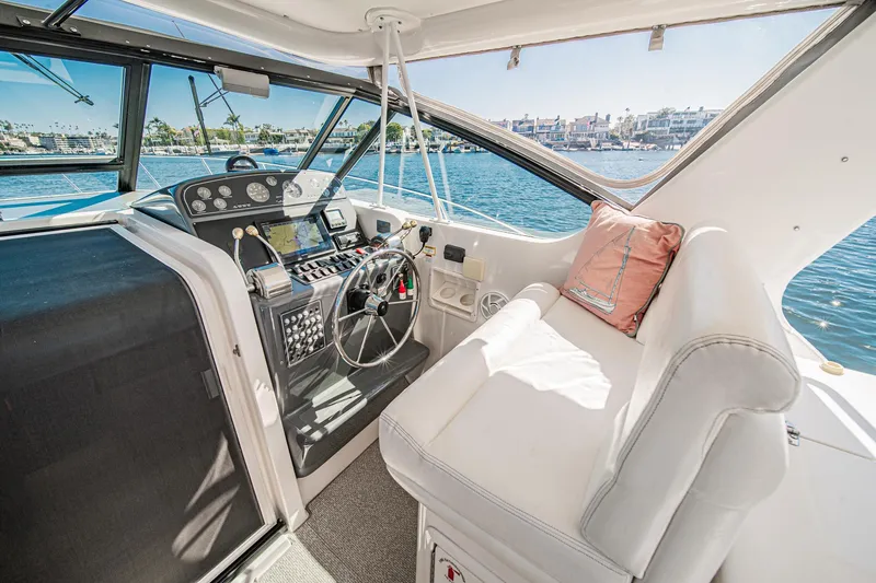 Slide: The Image of 2001 Tiara Yachts 3500 Open cockpit with steering wheel, controls, and seating by the water. - 29