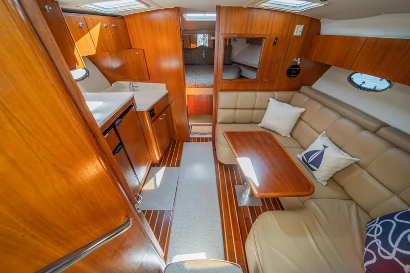 Slide: The Image of 2001 Tiara Yachts 3500 Open interior with wood finish, seating area, and kitchenette. - 32