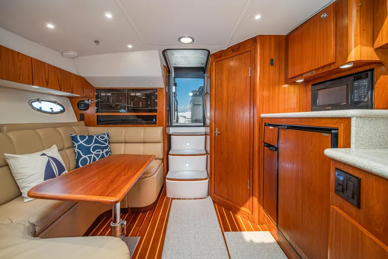 Slide: The Image of 2001 Tiara Yachts 3500 Open interior with wood finish, kitchenette, and seating area. - 33