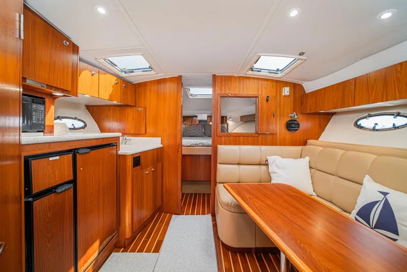 Slide: The Image of Interior of 2001 Tiara Yachts 3500 Open, featuring wood cabinetry and cozy seating. - 34