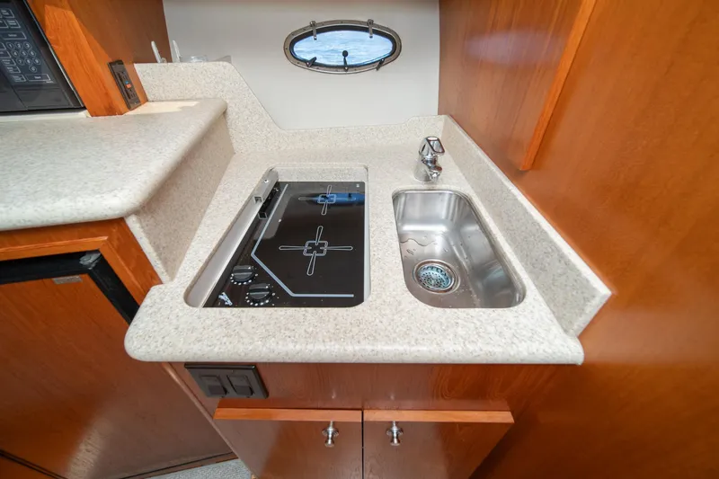 Slide: The Image of Compact kitchen area in a 2001 Tiara Yachts 3500 Open, featuring a stove and sink. - 41
