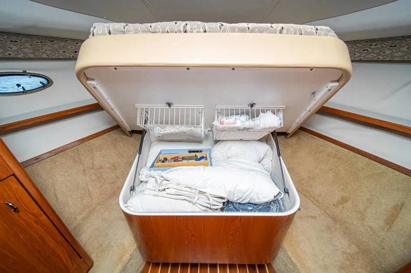 Slide: The Image of 2001 Tiara Yachts 3500 Open cabin storage with bedding and organized compartments. - 43