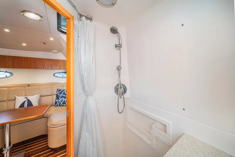 Slide: The Image of Interior of 2001 Tiara Yachts 3500 Open, featuring shower and cozy seating area. - 47