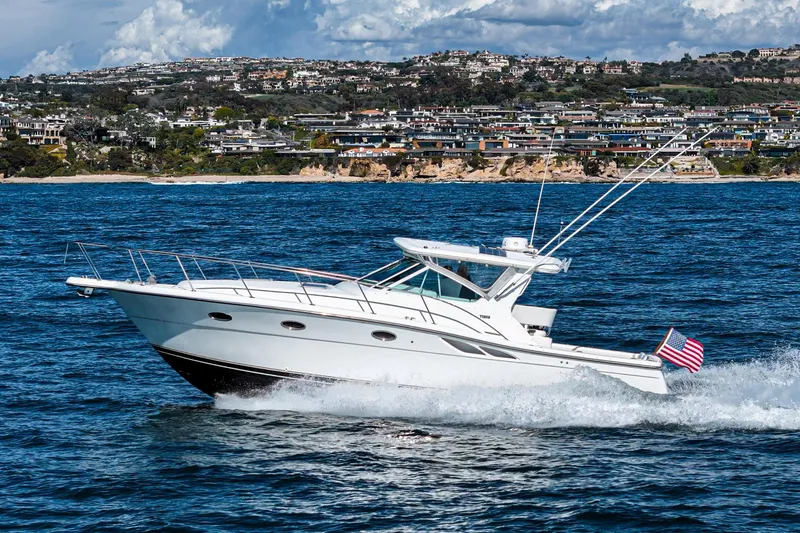 Slide: The Image of 2001 Tiara Yachts 3500 Open cruising on the ocean with coastal cityscape in background. - 6