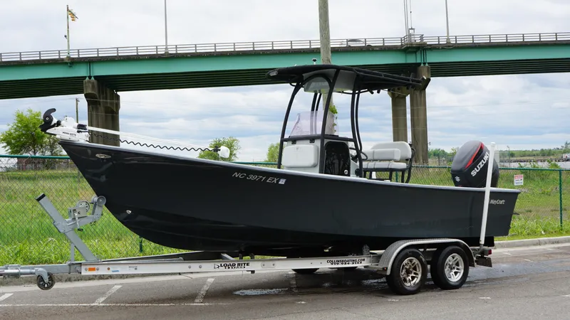 Slide: The Image of 2022 May-Craft 23 Cape Classic boat on trailer near bridge. - 1