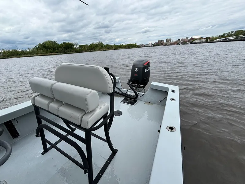 Slide: The Image of 2022 May-Craft 23 Cape Classic boat on a calm river with cityscape background. - 13