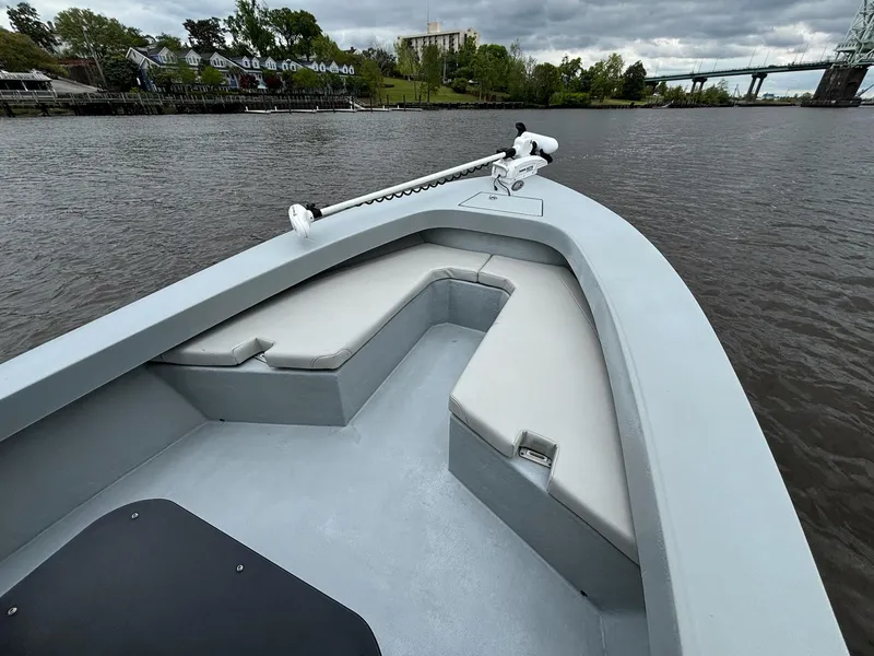 Slide: The Image of 2022 May-Craft 23 Cape Classic boat with cushioned seating on a calm river. - 9