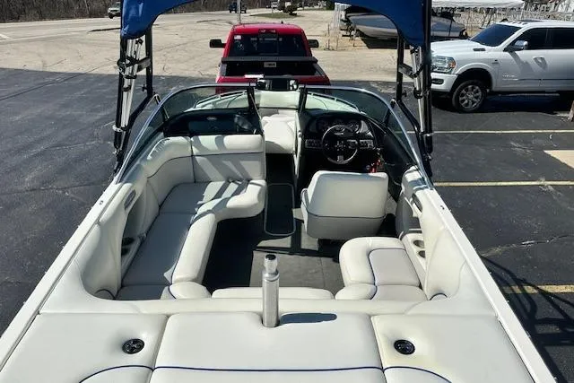 Slide: The Image of 2003 Malibu Wakesetter VLX boat with white interior, parked near vehicles. - 6