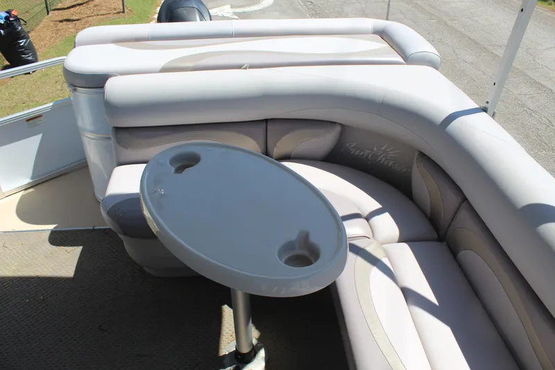 Slide: The Image of 2013 SunChaser 8520 Cruise boat interior with cushioned seating and a round table. - 13