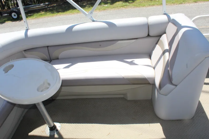 Slide: The Image of 2013 SunChaser 8520 Cruise boat interior with cushioned seating and a small table. - 18