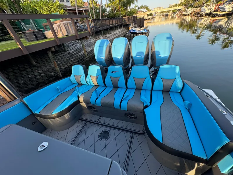 Slide: The Image of 2021 Midnight Express 37 Open boat with blue seating, docked by a calm waterfront. - 14