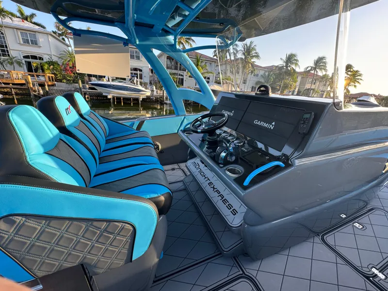 Slide: The Image of 2021 Midnight Express 37 Open boat interior with blue seating and advanced Garmin navigation system. - 15