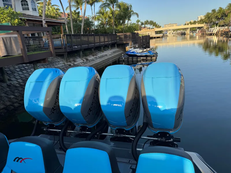 Slide: The Image of 2021 Midnight Express 37 Open boat with four blue outboard engines docked by a canal. - 16