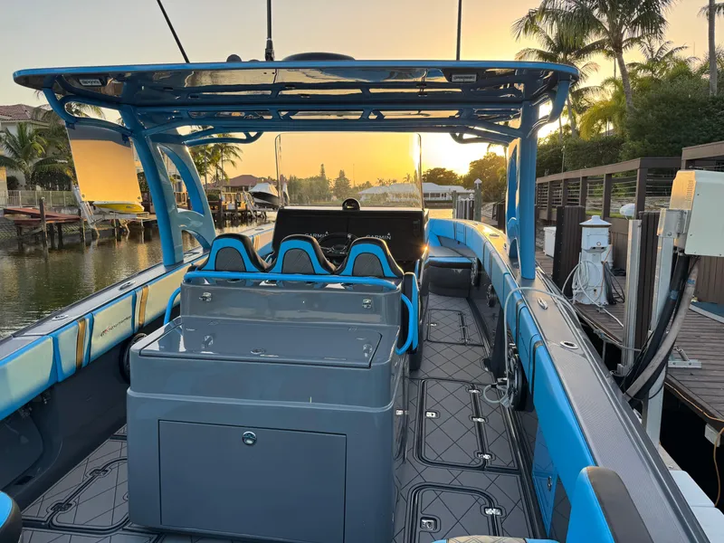 Slide: The Image of 2021 Midnight Express 37 Open boat at sunset, docked by palm trees. - 22