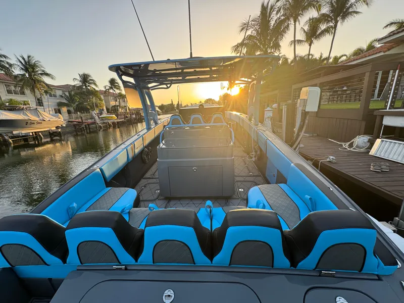 Slide: The Image of 2021 Midnight Express 37 Open boat at sunset, docked with palm trees in the background. - 23