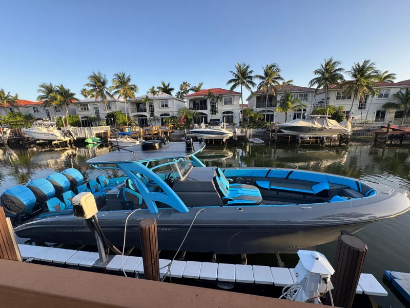 Slide: The Image of 2021 Midnight Express 37 Open boat docked in a scenic waterfront area with palm trees. - 3