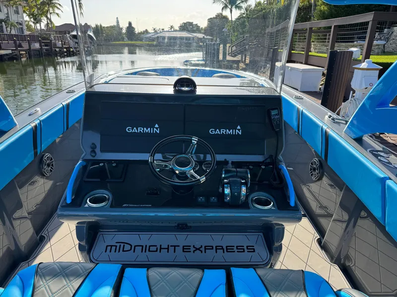 Slide: The Image of 2021 Midnight Express 37 Open boat cockpit with Garmin displays and blue seating. - 4