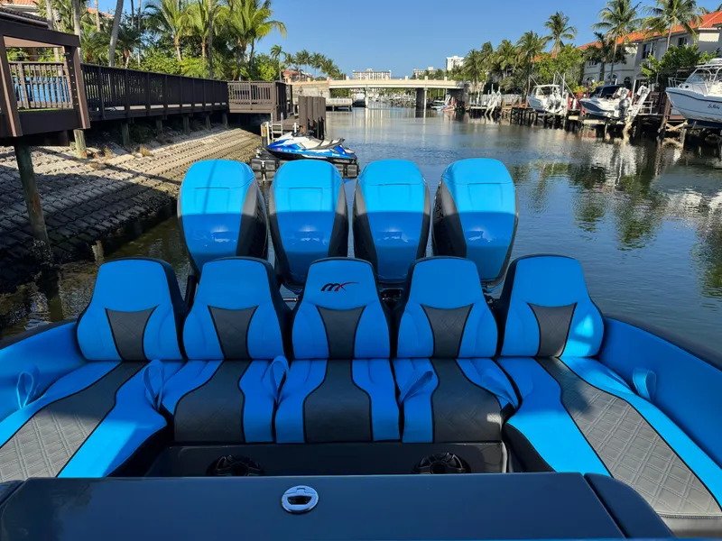 Slide: The Image of 2021 Midnight Express 37 Open boat with blue seating and multiple engines docked in a canal. - 5