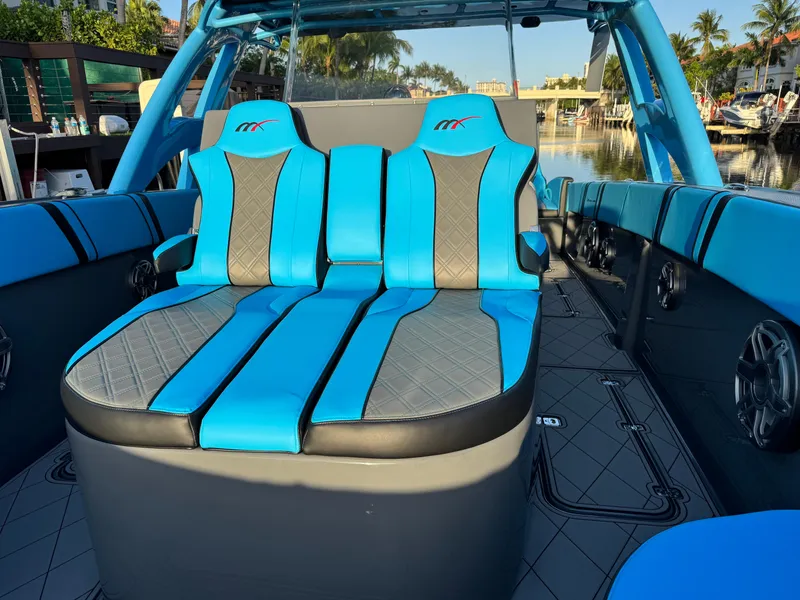 Slide: The Image of 2021 Midnight Express 37 Open boat with blue and gray seating, docked by a canal. - 9