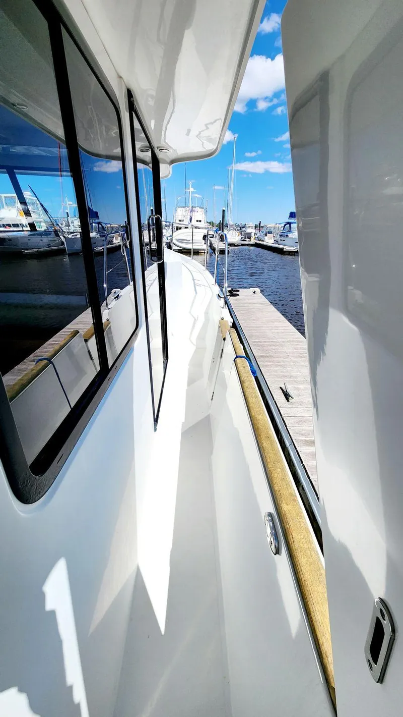 Slide: The Image of 2015 Beneteau Swift Trawler 34 docked at marina, side view with clear blue sky. - 10