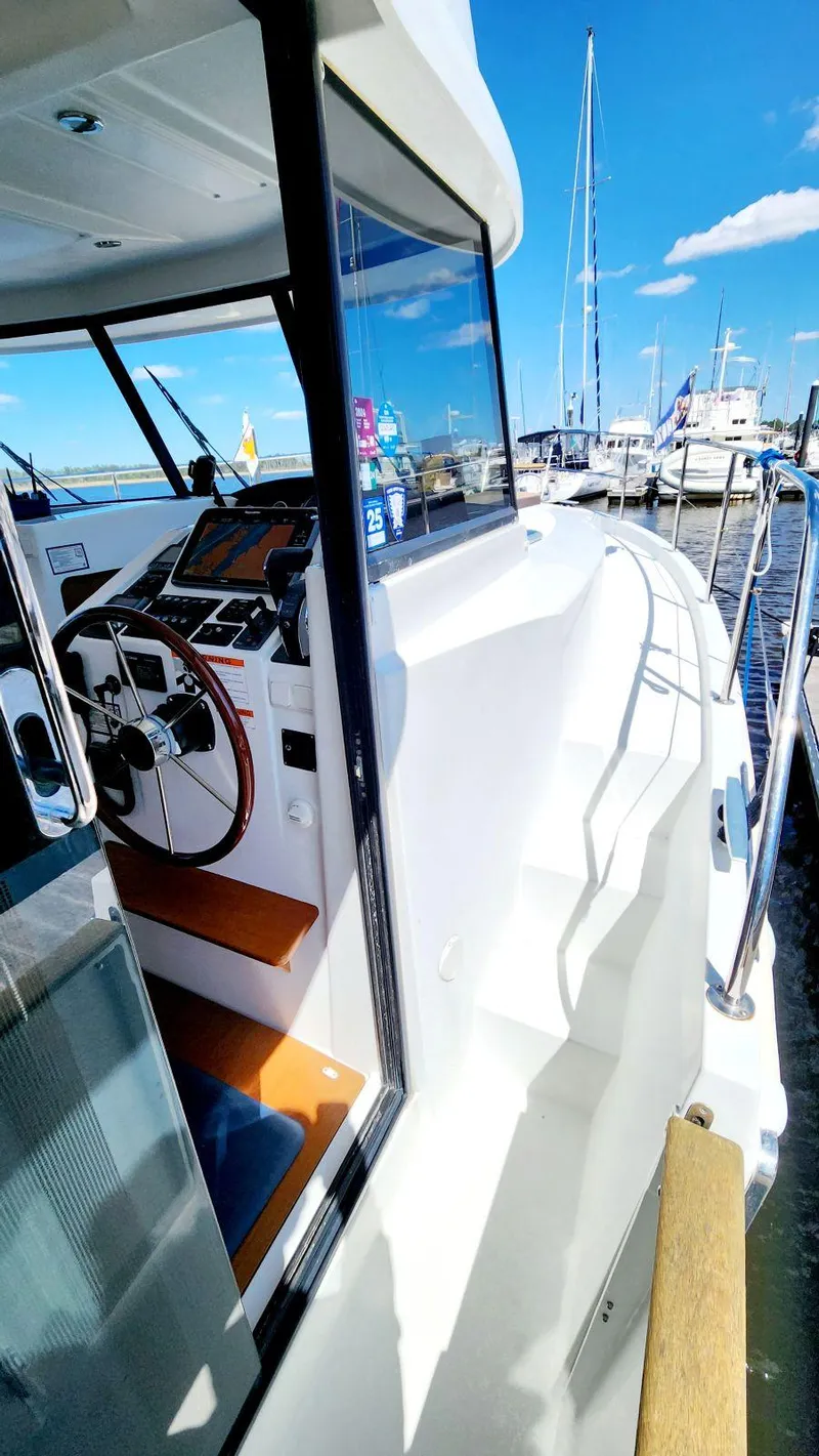 Slide: The Image of 2015 Beneteau Swift Trawler 34, docked, showcasing helm and deck under clear blue sky. - 11