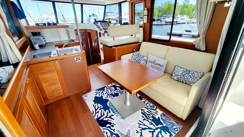 Slide: The Image of Interior of 2015 Beneteau Swift Trawler 34 with cozy seating and nautical decor. - 14