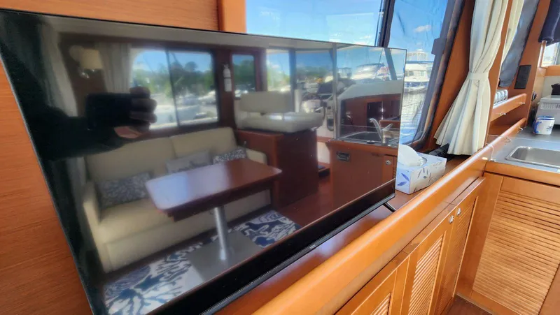 Slide: The Image of Interior of 2015 Beneteau Swift Trawler 34 with TV, sofa, and kitchen area. - 16