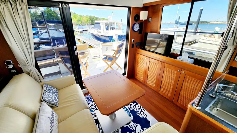Slide: The Image of Interior of 2015 Beneteau Swift Trawler 34 with cozy seating and marina view. - 17