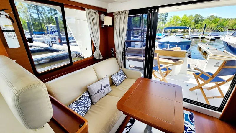 Slide: The Image of Interior of 2015 Beneteau Swift Trawler 34 with cozy seating and marina view. - 18