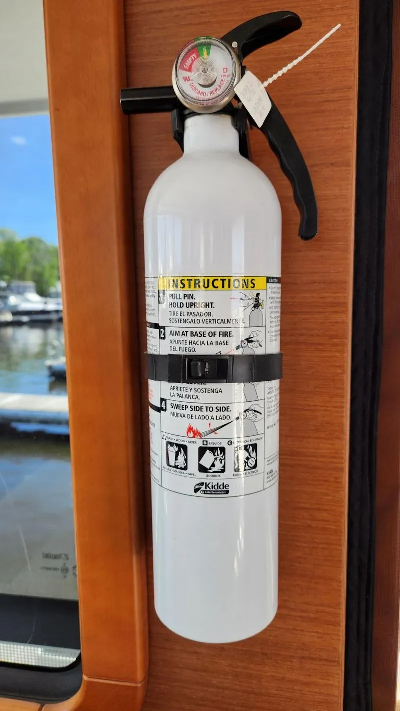 Slide: The Image of Fire extinguisher mounted on 2015 Beneteau Swift Trawler 34, with safety instructions visible. - 21
