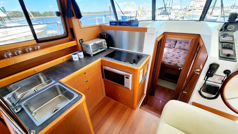 Slide: The Image of Interior of 2015 Beneteau Swift Trawler 34, featuring kitchen and cabin area. - 22