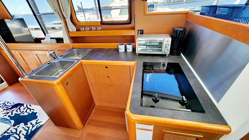 Slide: The Image of 2015 Beneteau Swift Trawler 34 kitchen with dual sinks, stove, and appliances. - 23